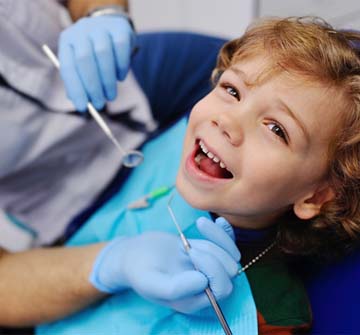 Young boy smiling while visiting pediatric dentist in Nashua for dental sealants