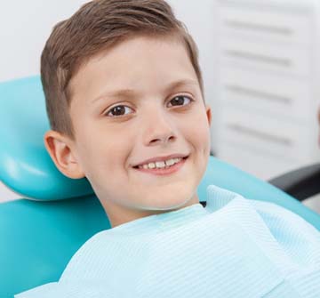 Closeup of boy smiling while visiting pediatric dentist in Nashua for dental sealants
