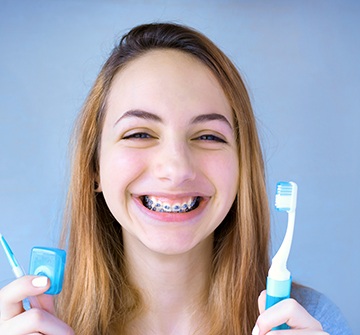 a girl with braces holding a toothbrush