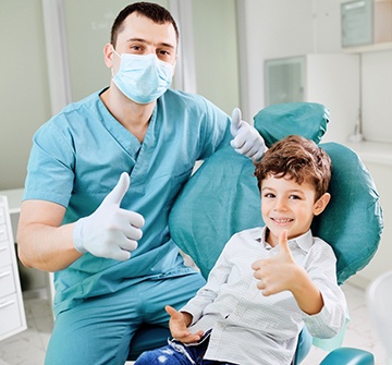 Nashua pediatric dentist and child giving thumbs up in chair