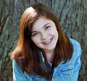 Teen girl with traditional orthodontics smiling