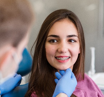 Young girl with braces smiling at orthodontist