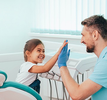 Smiling child giving dentist a high-five