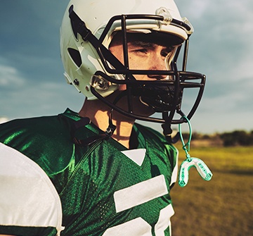 Teen with athletic mouthguard attached to football helmet
