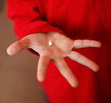 Child holding tooth after extraction