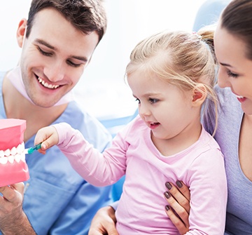 Toddler looking at smile model after receiving dental sealants