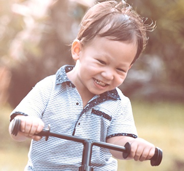 Toddler riding tricycle after tooth colored filling treatment