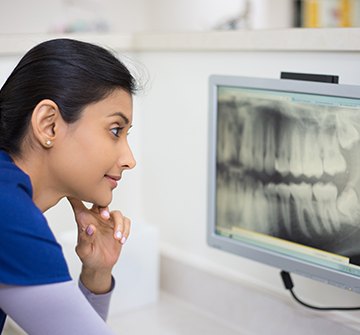 Dental team member looking at digital x-rays