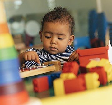 Toddler playing with blocks after frenuloplasty and frenectomy