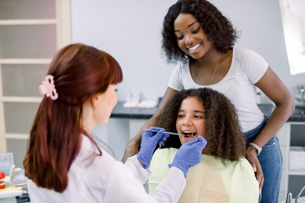 Pediatric dentist in Nashua examining child's teeth