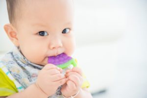 Infant chewing on toy from Nashua pediatric dentist 