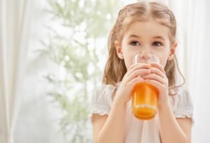 a child drinking a glass of juice