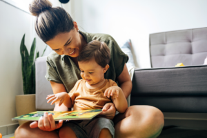 a parent and young child reading a book together