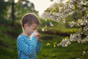 a child blowing his nose during flu season