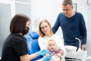 parents and their child during their first dental appointment